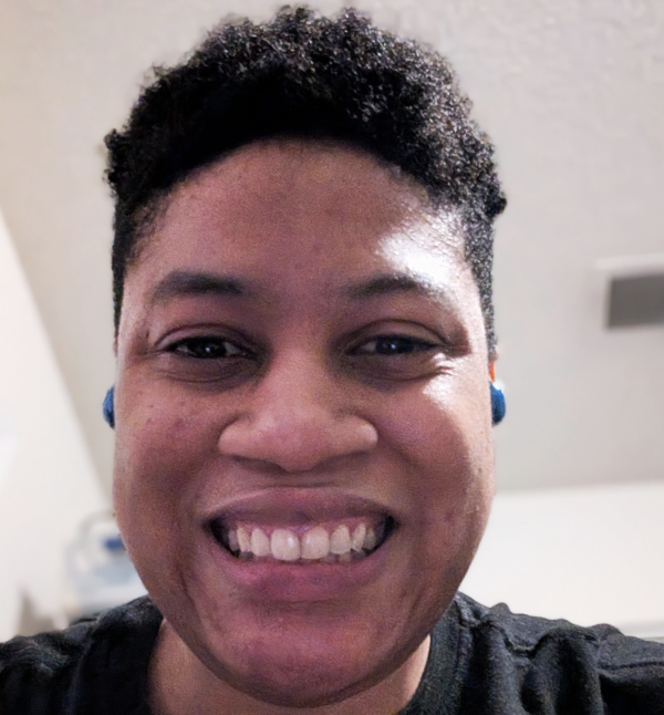 Jennifer is smiling into the camera. She has short dark brown hair and is wearing a black top.